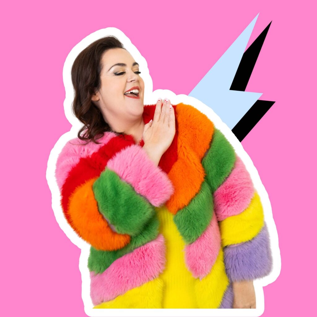 Rosie Parsons in colourful rainbow coat dusting her shoulder off for the category photography tips for women who want to look amazing in photos